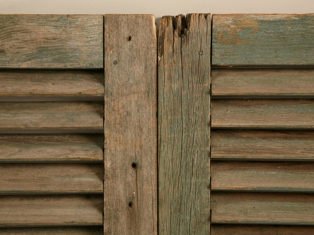 With their time-worn and weathered green paint, this incredible pair of antique English shutters are ready to add extra style and pizazz to your home. Whether they are utilized over an existing window to shield Mother Natures bright sunshine, hinged