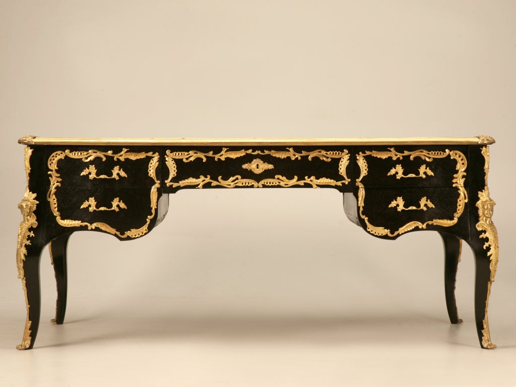 Unique one of a kind vintage French style desk or bureau plat. This desk offers a true ebonized finish that contrasts ever so elegantly with the glamorous Doré ormolu trim. Five drawers make using this desk an absolute breeze, as they all glide