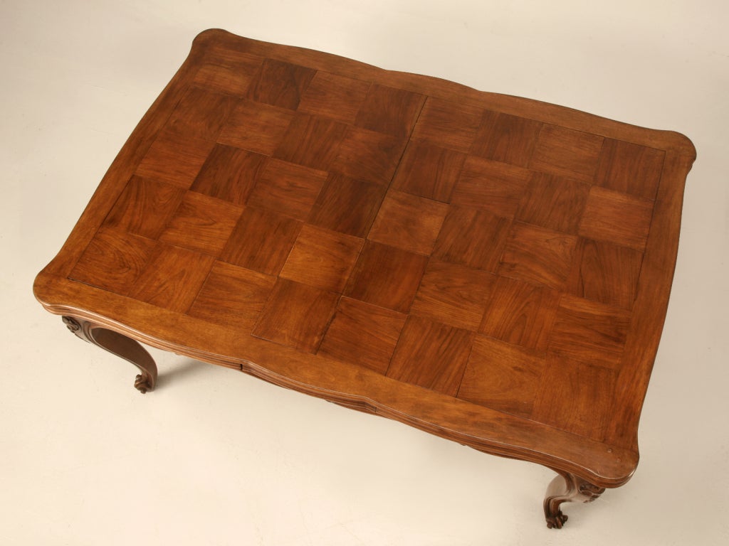 Exquisite large hand-carved Italian walnut draw-leaf dining tables like this one are few and far between. This one is stunning from its outstanding medium colored finish showcasing the exotic grain of the walnut checker board top down to its strong