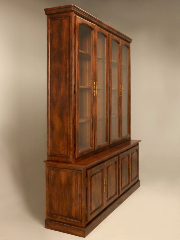 Dynamite proportions mated with stellar good looks are attributes of this fine French walnut cabinet. Showcasing time honored old world craftsmanship, this walnut bookcase offers a plethora of options. The wooden shelves let us know that it was