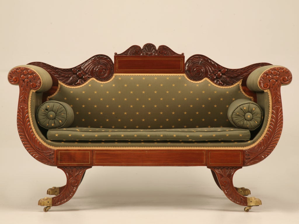 Phenomenal petite settee in the Empire style. This fantastic find is attributed to Charles-Honoré Lannuier, a famous French-born American cabinetmaker. Upholstered in a correct period style fabric, the arms are somewhat faded. Many intricate carved
