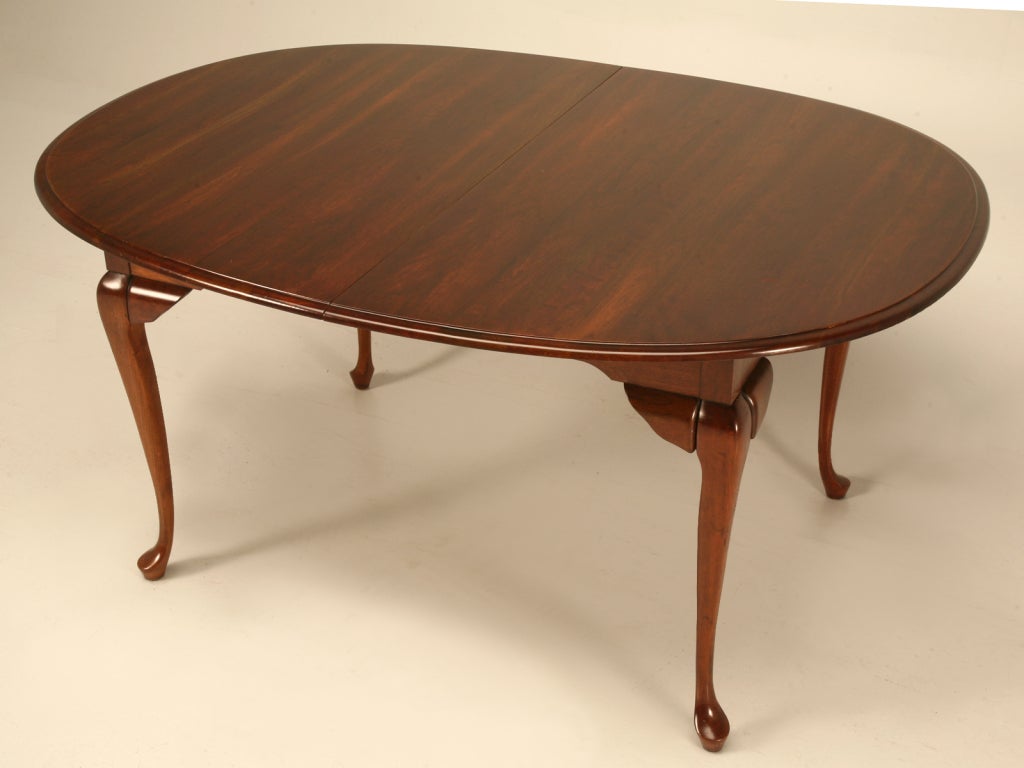 Outstanding vintage American Queen Anne style dining table. This vintage table offers traditional styling, 2 extra leaves, and a distinctive cherry finish, too. Sturdy construction offers stability and a great oval shape make this table a perfect