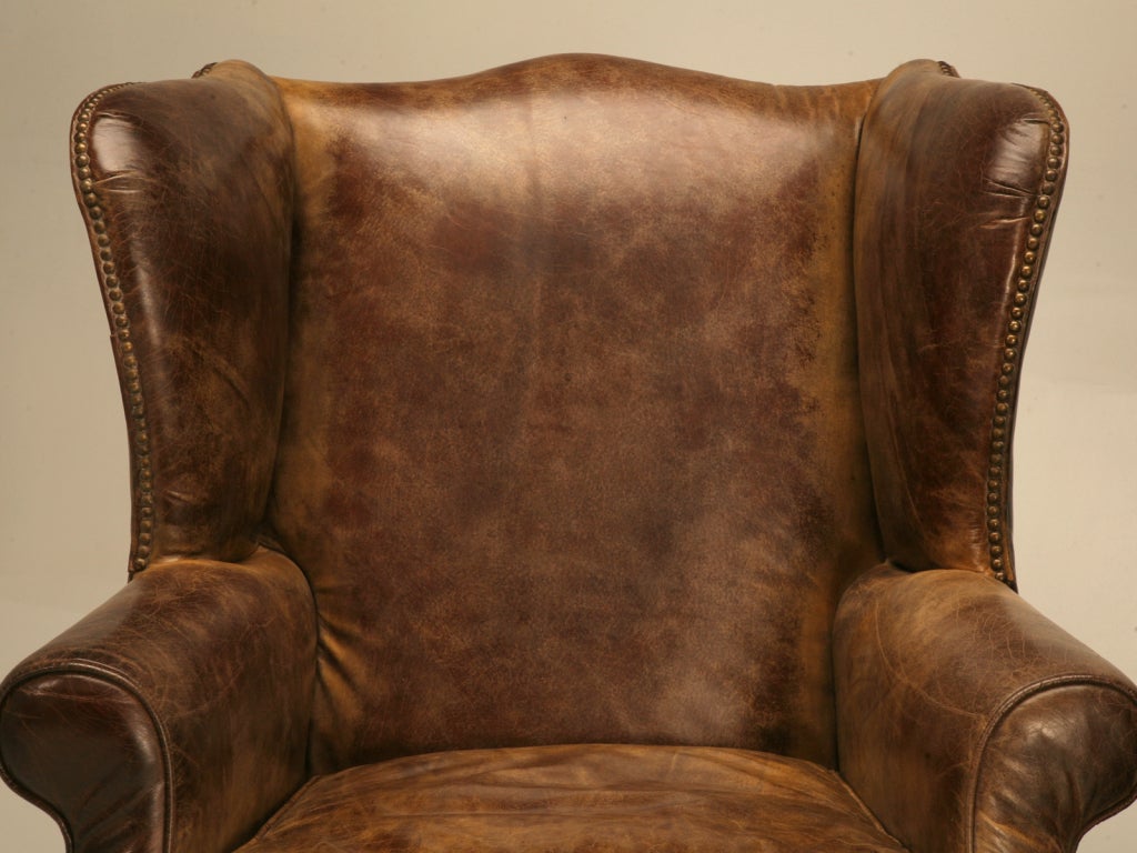 Inviting, striking and ever so comfortable, this fine pair of vintage wing back chairs are off the charts. Showcasing multiple shades of brown, these chairs have that old Ralph Lauren bomber jacket appearance we all love, coupled with that
