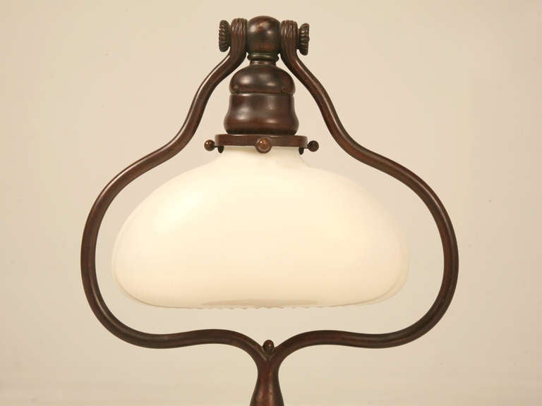 Original signed (image 10) Tiffany Studios solid bronze desk or table lamp. In very good condition, especially for its age, this lamp retains its original untouched mottled brown patina.  Illuminated, the glow this lamp generates is incomparable