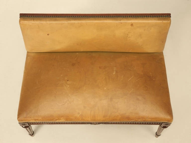 Circa 1930's French Louis XVI style bench with the most beautiful original leather covering. Other than a small amount of refinishing touch ups on the fluted legs, this Louis XVI style bench did not require any further restoration. Extremely rare