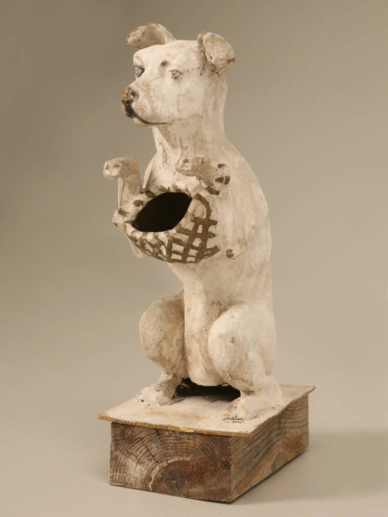 Circa 1900 French Paper Mache dog that we think may have been used as a candy bowl. The dog is securely mounted on a block of wood for stability.
