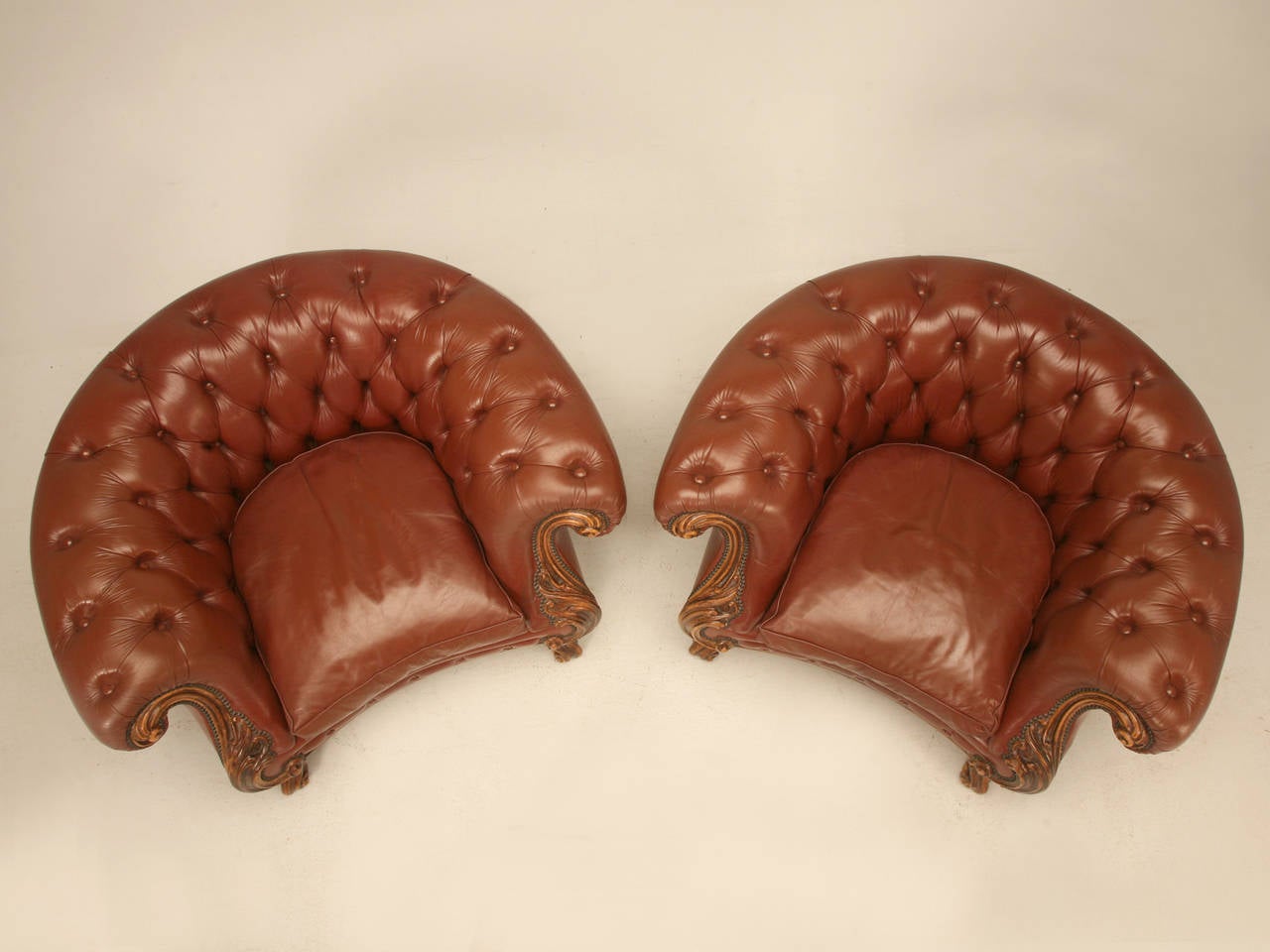 Pair of extremely comfortable leather Chesterfield armchairs, (matching sofa is available) with a bit of a French twist to their style. Nicely carved details to the arms and feet and probably made in the 1960s if I had to guess. The leather used was