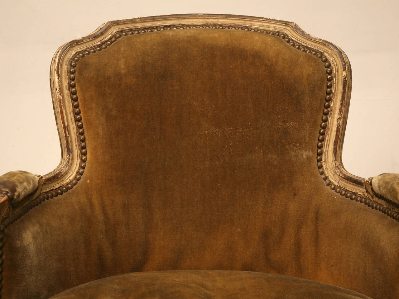 This is a very old French bergere chair in great old paint, that no one has touched for a long time. There is no real way to determine if the chair was born this way, but if it wasn't, it certainly was painted over 100 years ago. 

The expert at
