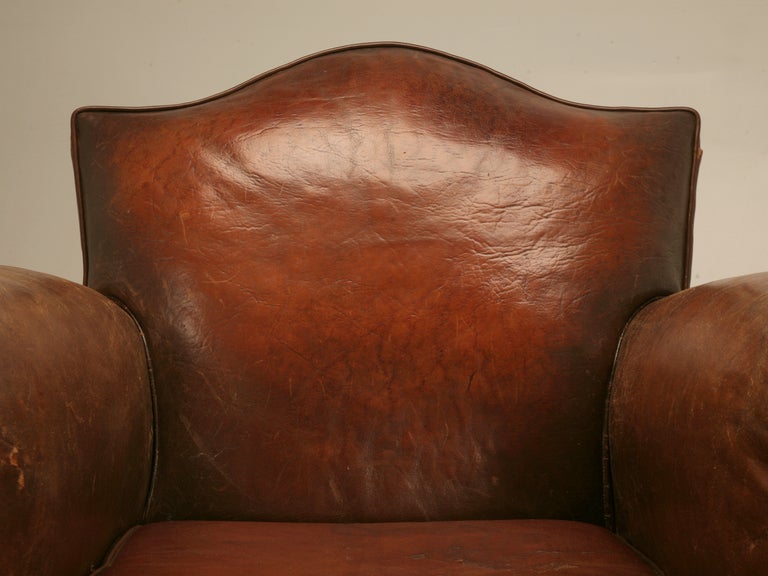 Unbelevable pair of original vintage French leather club chairs retaining their striking and spectacular original leather. Spot on with tons of character and charm, this pair offer the classic 