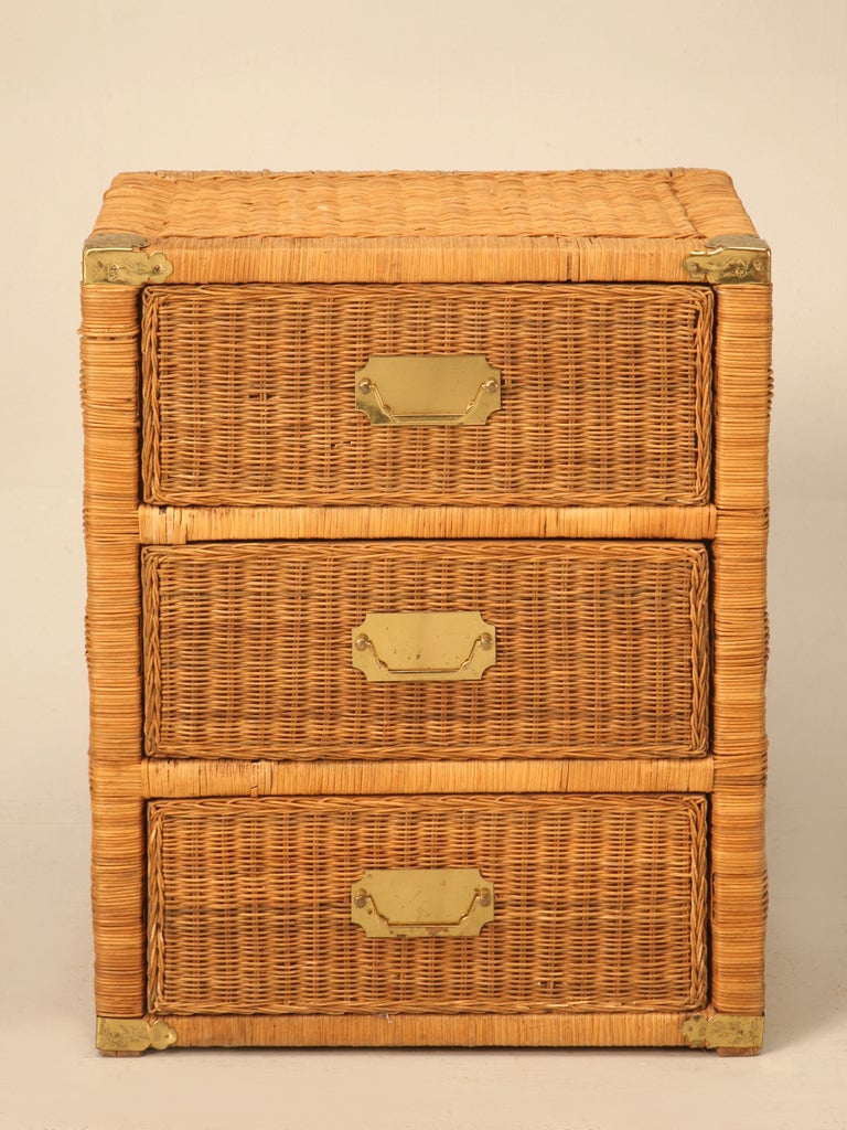 Casual vintage rattan or woven wicker 3 drawer campaign style chest or nightstand with brass corners and pulls. This great chest offers a unique opportunity to own a casual Tommy Bahama beach style chest that will add casual elegance in any room of