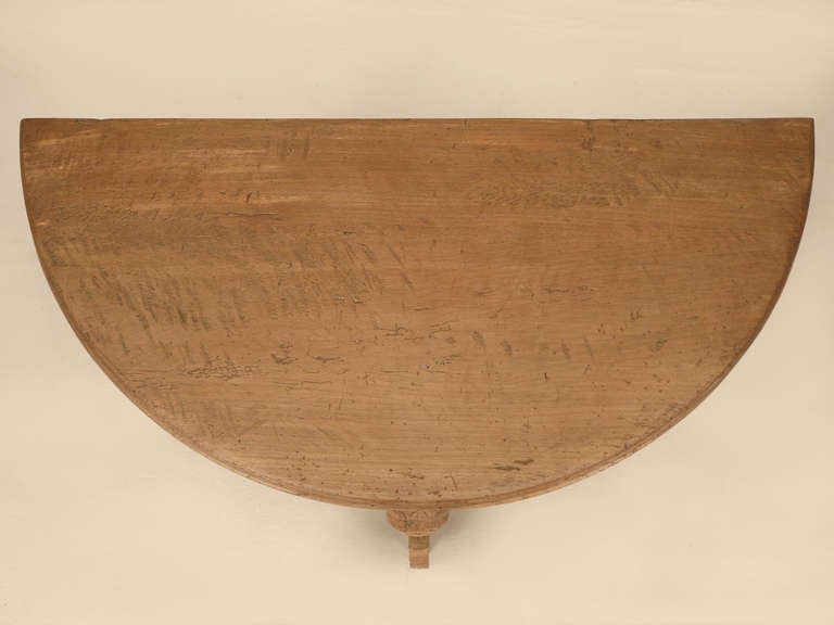 With a restored finish to the top and lower shelf, this antique French white oak table offers unique hand carved elephant legs. Structurally sound.