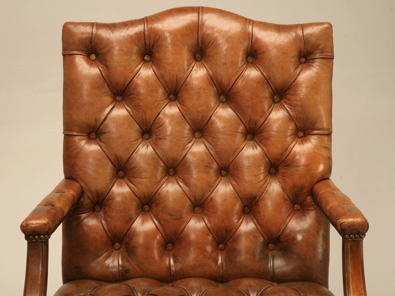 Pair of vintage English armchairs done in a button tufted, or more commonly referred to as a Chesterfield style. The chairs sit quite nice, and the leather appears to be about 60-70 years old; please note the repair to the backside of one of the