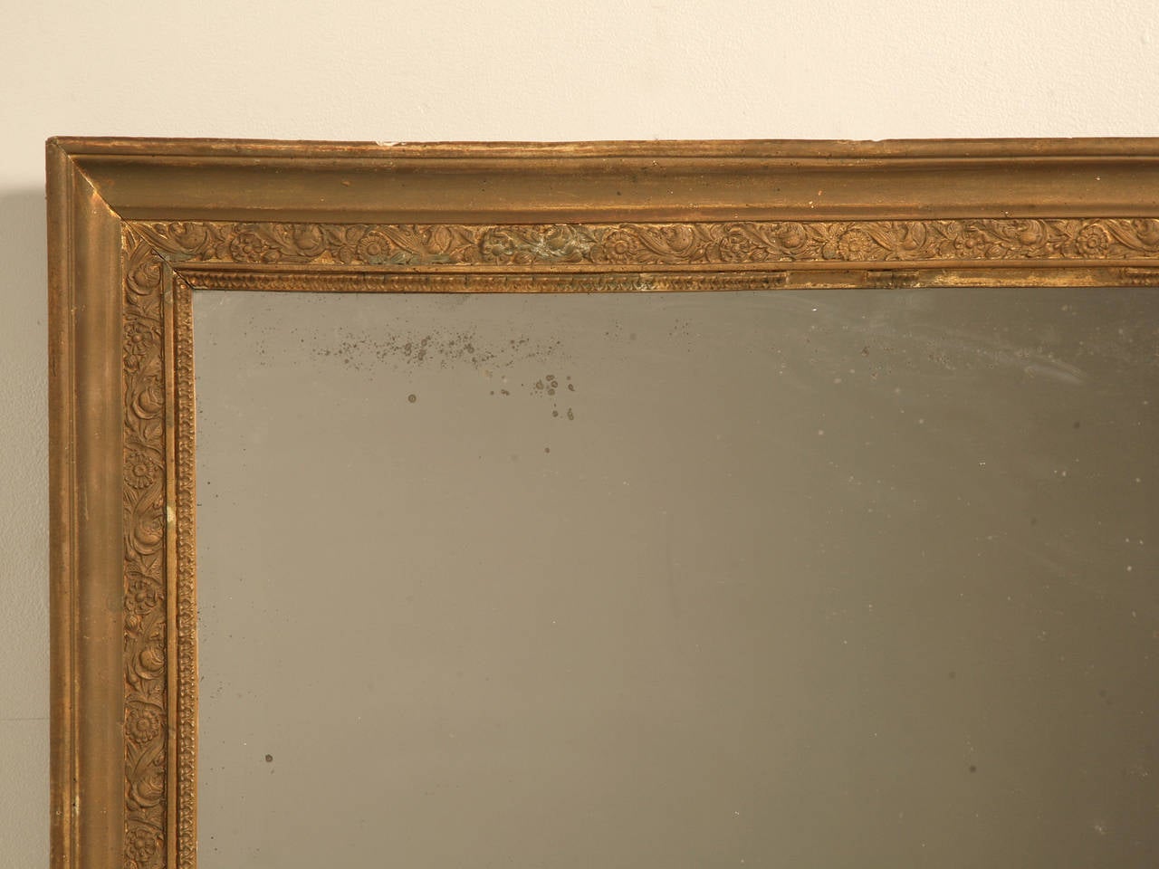 French gilded wood frame with its original two-piece mirror still intact, circa 1800s. Unbelievable patina to the glass that is virtually impossible to duplicate with todays distressing techniques. The gilding has seen better days however, but has