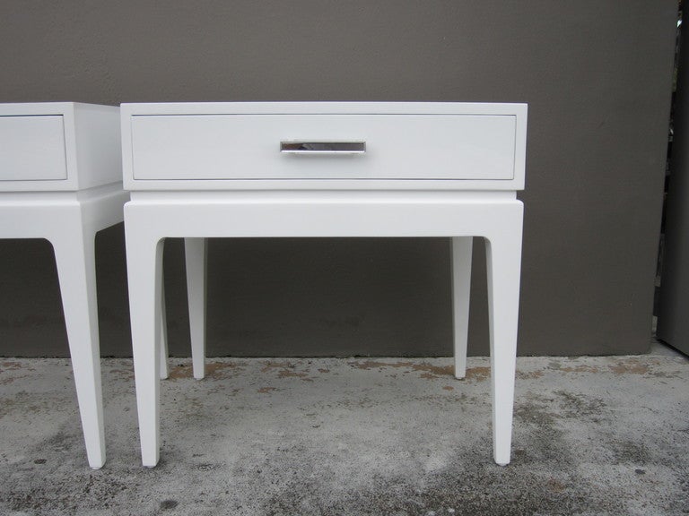 Pair of white lacquer bedside tables with single drawer. The handle is rectangular and made of lucite. The tables are finished all around so may be floated in a room.