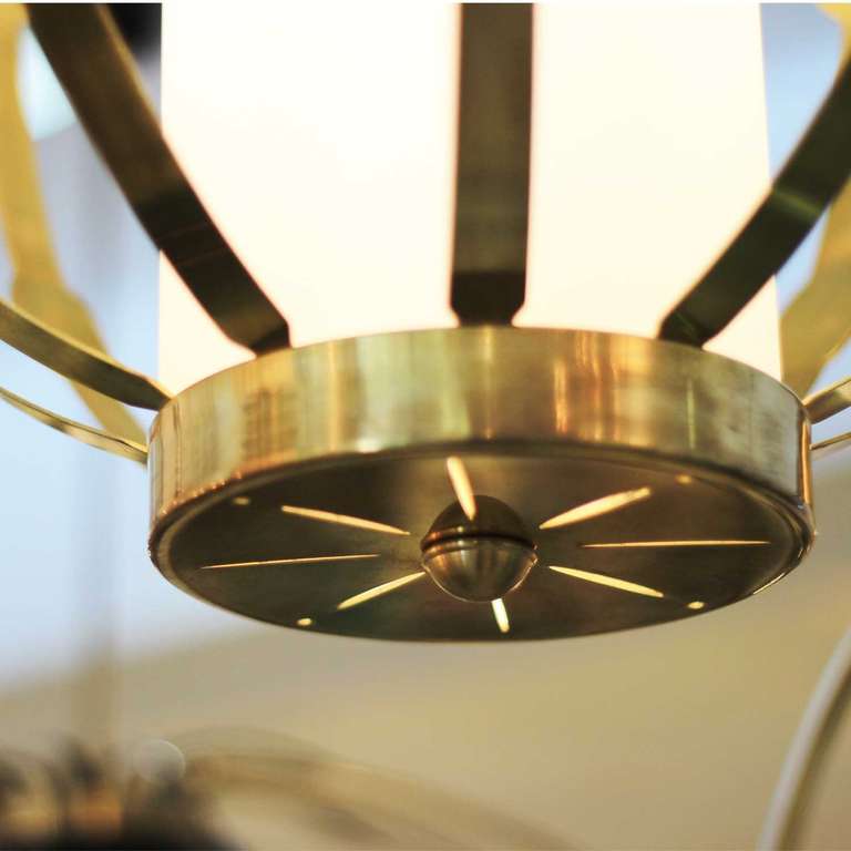 Single vintage brass lantern with central satin glass cylinder for filtering light source.
