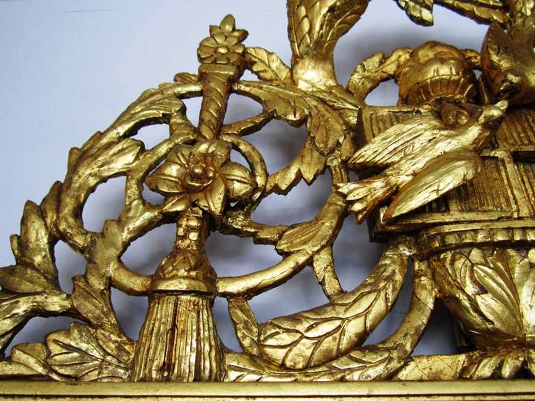 Carved and gilt wood late 18th century  pier mirror with ornamental crest depicting leaves swag and tassels. The original mirror has some faint but expected mercury loss.
