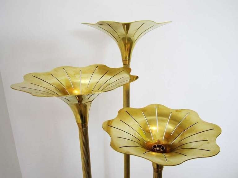 Pair of Italian floor lamps featuring three high flowers of brass with radiating cutouts and  fluted stems. The  lamps can be turned on or off by a foot switch.