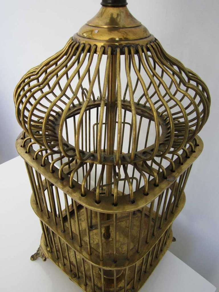 Pair of vintage brass birdcage lamps with miniature dangling perches, bowls and functioning, latched doors.