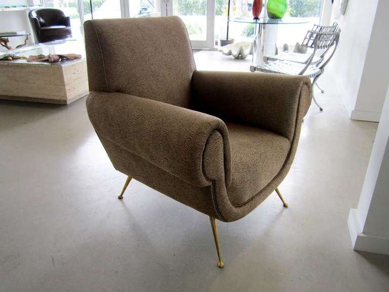 Pair of Italian 1960's arm chairs featuring muted gold faux snake skin upholstery tapered brass legs.