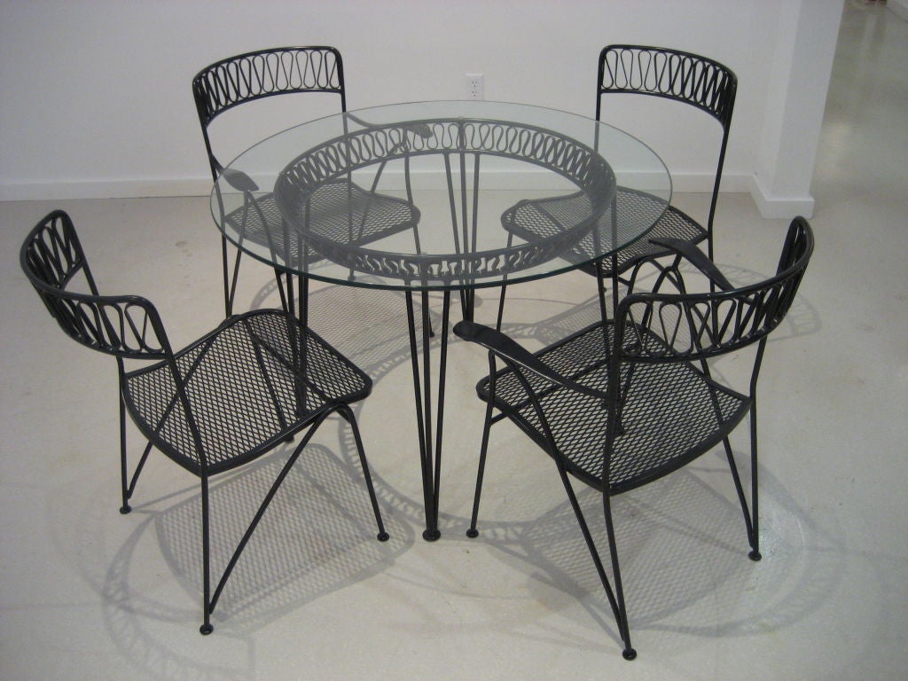 Classic ribbon pattern by Salterini-- wrought iron which has been professionally powder coated. The set comprises a table with glass top , two armchairs and two side chairs.