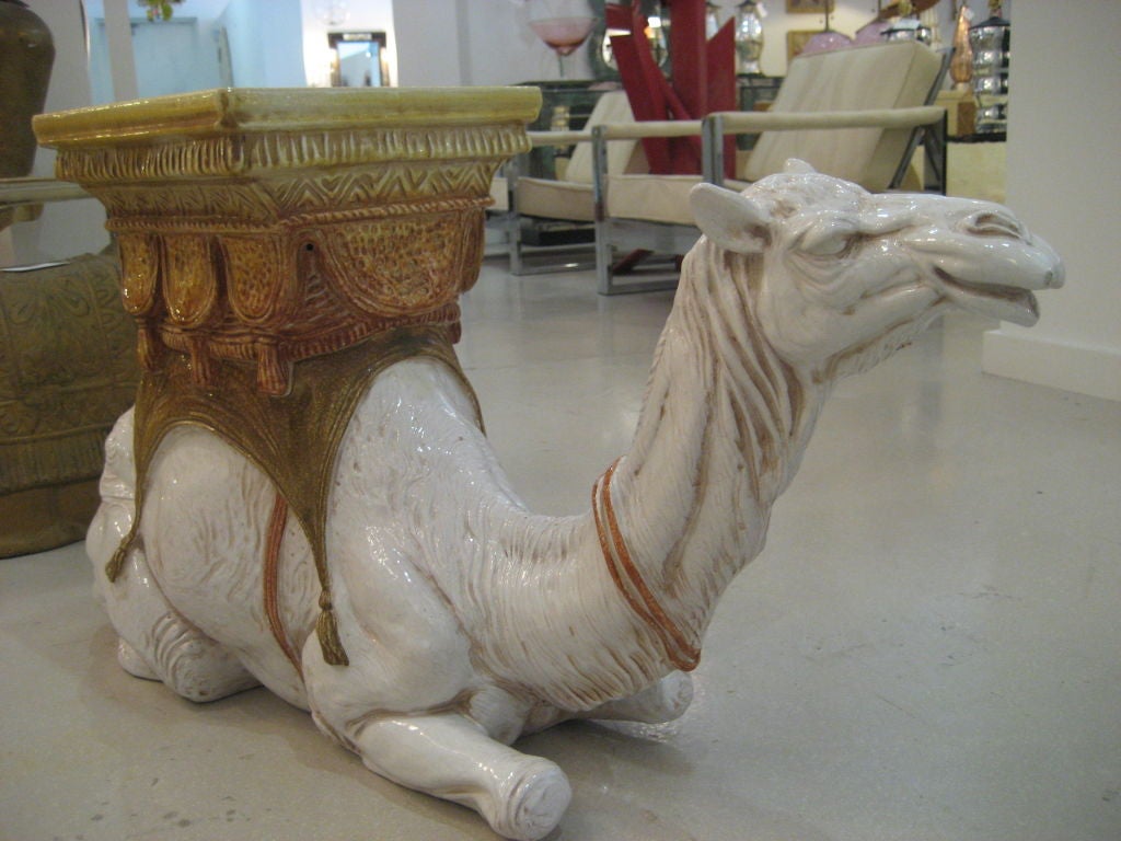 Italian garden seat in the form of a camel in hues of white , gold and amber.