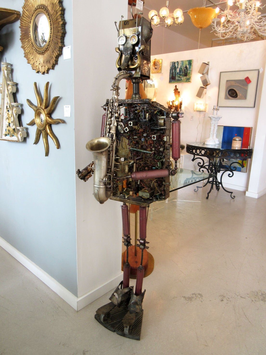 Tall robot sculpture made out of a vast array of different found metal components. Sculpture is signed on the right side of its head