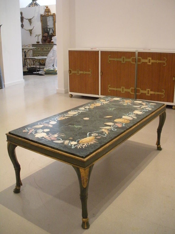 Dramatic poltchrome table signed Emilio Martelli Firenze with scagliola decorated green marble top table with inlaid corals, shells, ribbons, mollusk on painted decorated base with hoof feet.