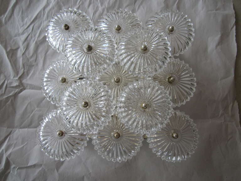 European flush mount light fixture with multiple glass flower like discs - dimensional and attractive from all angles. Four are available- sold individually.