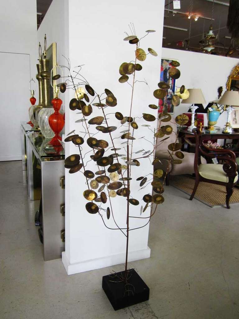 Brass Curtis Jere tree sculpture featuring circular leaves in the style of his other well known "Raindrops" with spindly roots that cover the black base where there is a small oval piece of brass with his signature.