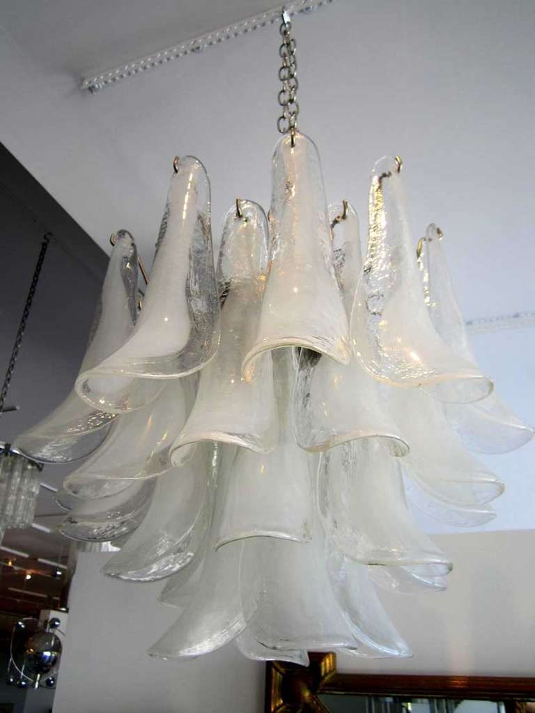Vintage Murano glass light fixture by Mazzega. The fixture has a nickel plated armature with multi- tiers of clear to white glass horn shaped pendants.
The fixture is re-wired and working. There are 5 sockets which house candelabra size bulbs.
