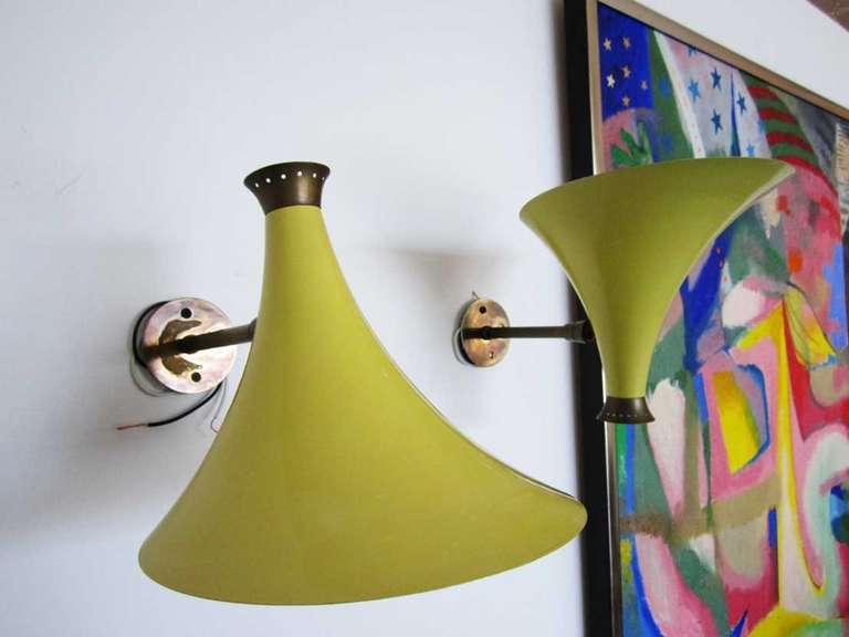 Pair of  yellow enamel cone shaped sconces featuring brass hardware and movable hinge.