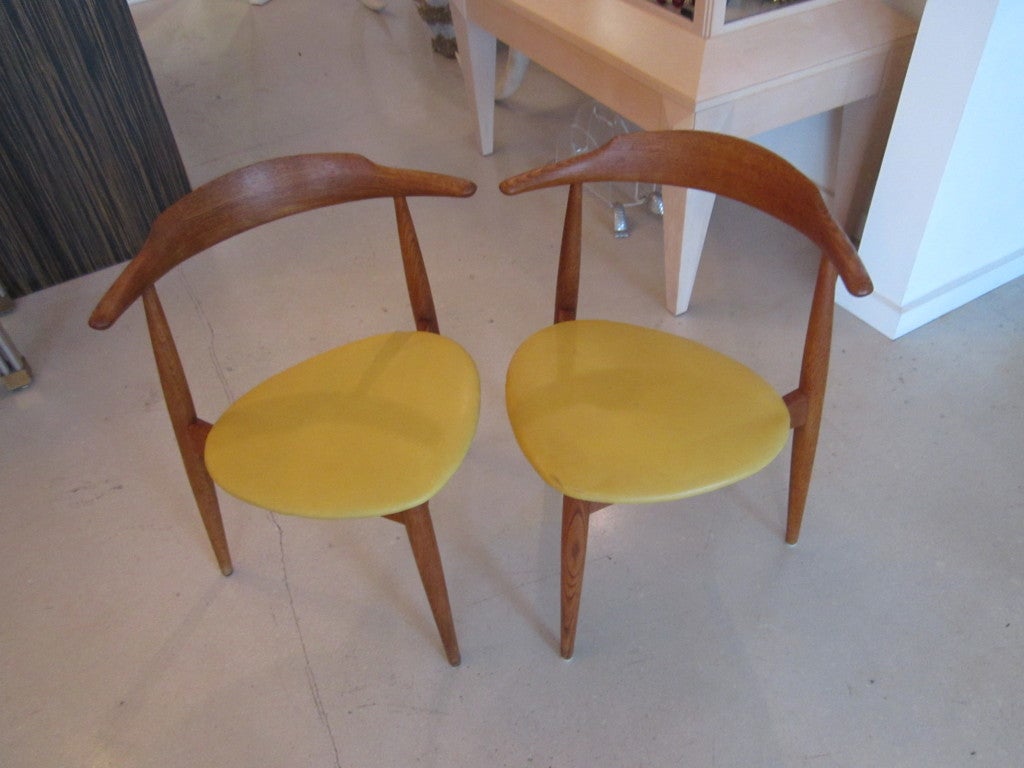 Vintage set of four Hans Wegner for Fritz Hansen  oak three legged chairs with original mustard yellow cushions.