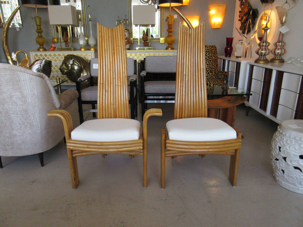 Set of six rattan high back dining chairs by American manufacturer McGuire. The set of six is composed of two armed chairs and four sides. As pictured, some pieces feature McGuire's signature 'M.' The width of the two armchairs: 29.5 inches.