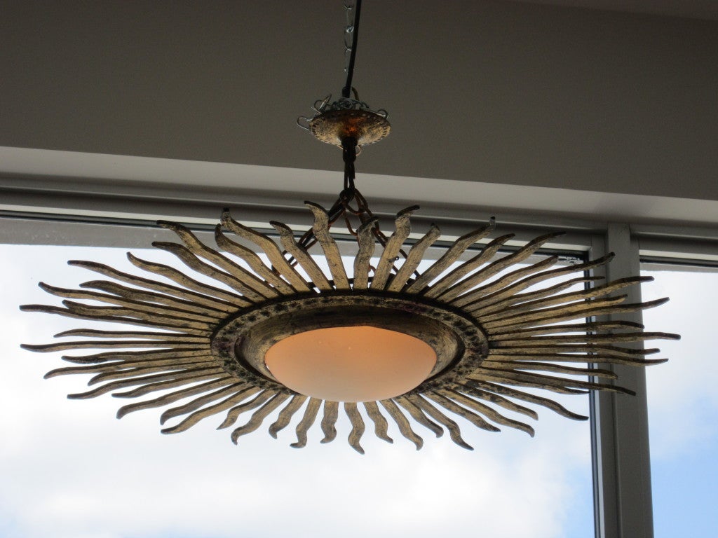 Gold gilt metal sunburst light fixture which hugs the ceiling- but not completely flushmount.