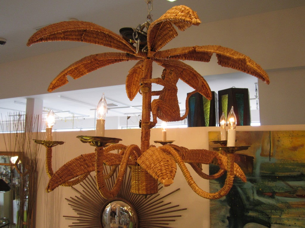 Rattan palm tree chandelier with monkey signed by Mexican artist Mario Lopez Torres. The fixture has six arms and is all woven with occasional brass details.