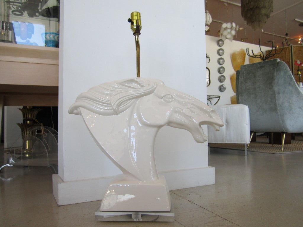 White ceramic stylized horse head lamp with brass hardware.