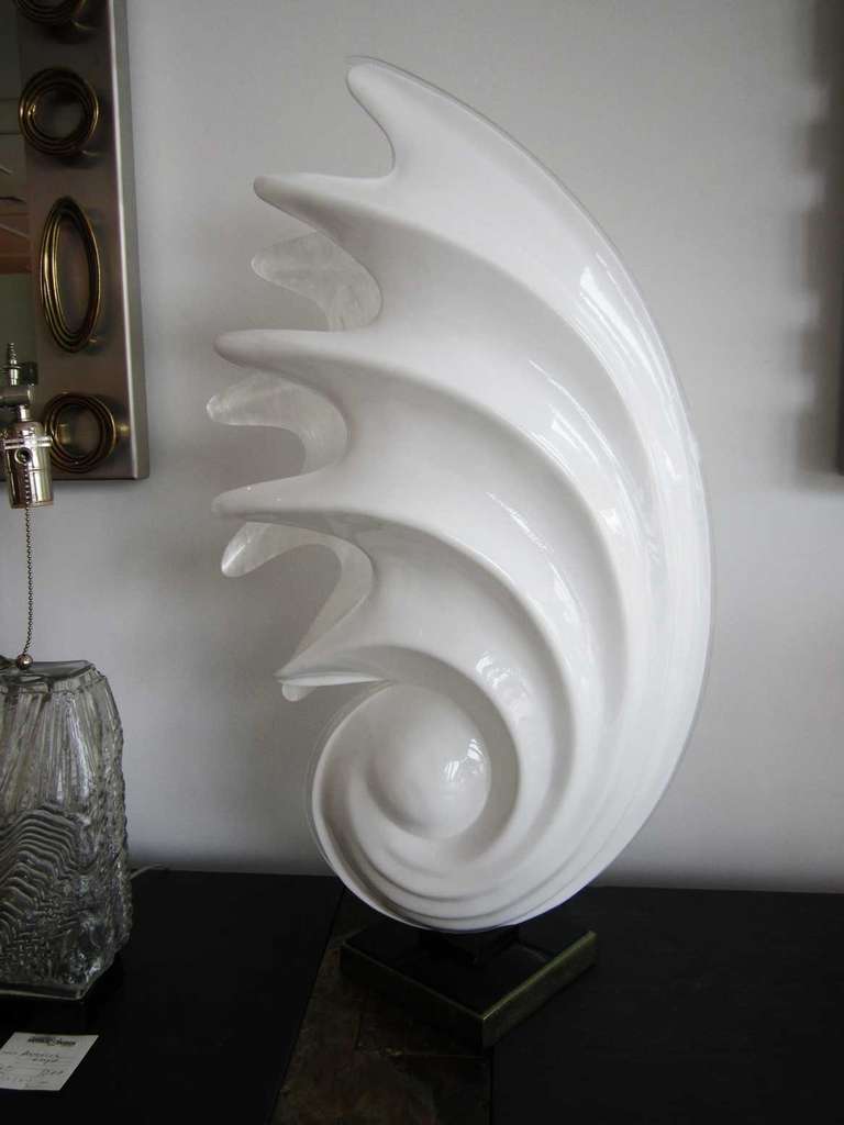 Spiral shell table lamp by Rougier. The front side of lamp is plain white, while the back is a faux mother of pearl white. It has the original Rougier tag on the side of the base, the original, 