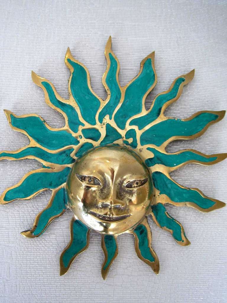 Pair of Pepe Mendoza Aztec sun god ornaments made of brass with turquoise ceramic inlay detail. The hardware is signed and has drill hole on upper ray to attach hanging device. May also be mounted to cabinet façade.