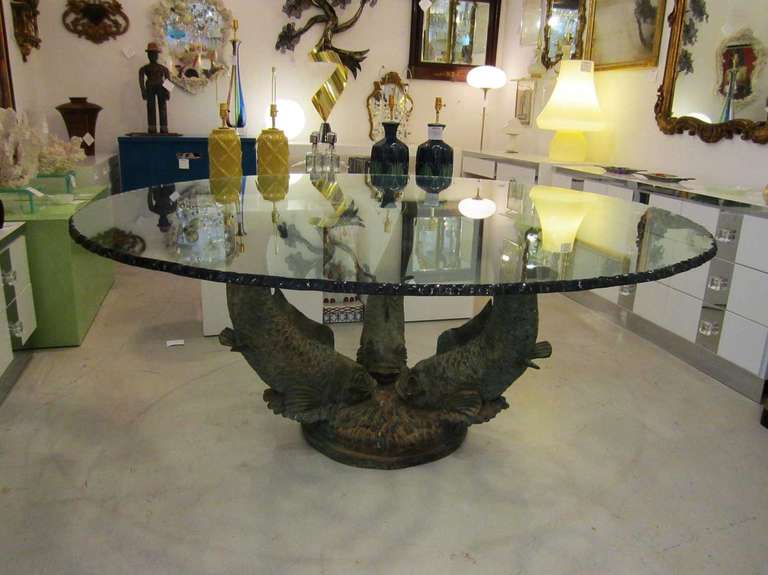 Bronze koi fish center table  featuring a large  thick chiseled cut glass top.
The table is very sculptural and attractive from all angles.