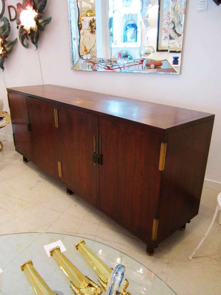 Baker cabinet made out of walnut, featuring four doors with three pull out drawers on the left hand side. On the right hand side there are no drawers, but there is hardware to place for a single shelf.