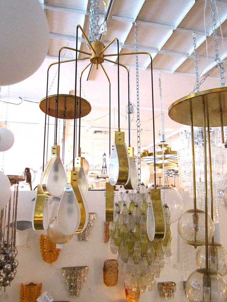 Mod brass and frosted glass teardrop light fixture with cascading pendants.