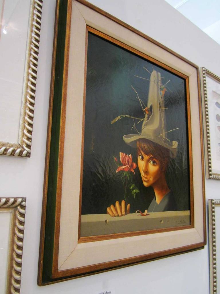 A whimsical surreal oil painting of a boy with a dew dropped open rose in his hand and nesting birds peeking out from holes in his tall hat.  Painted by listed French artist Jean-Pierre Clement and signed in the bottom Jean de la Lune, Clement,