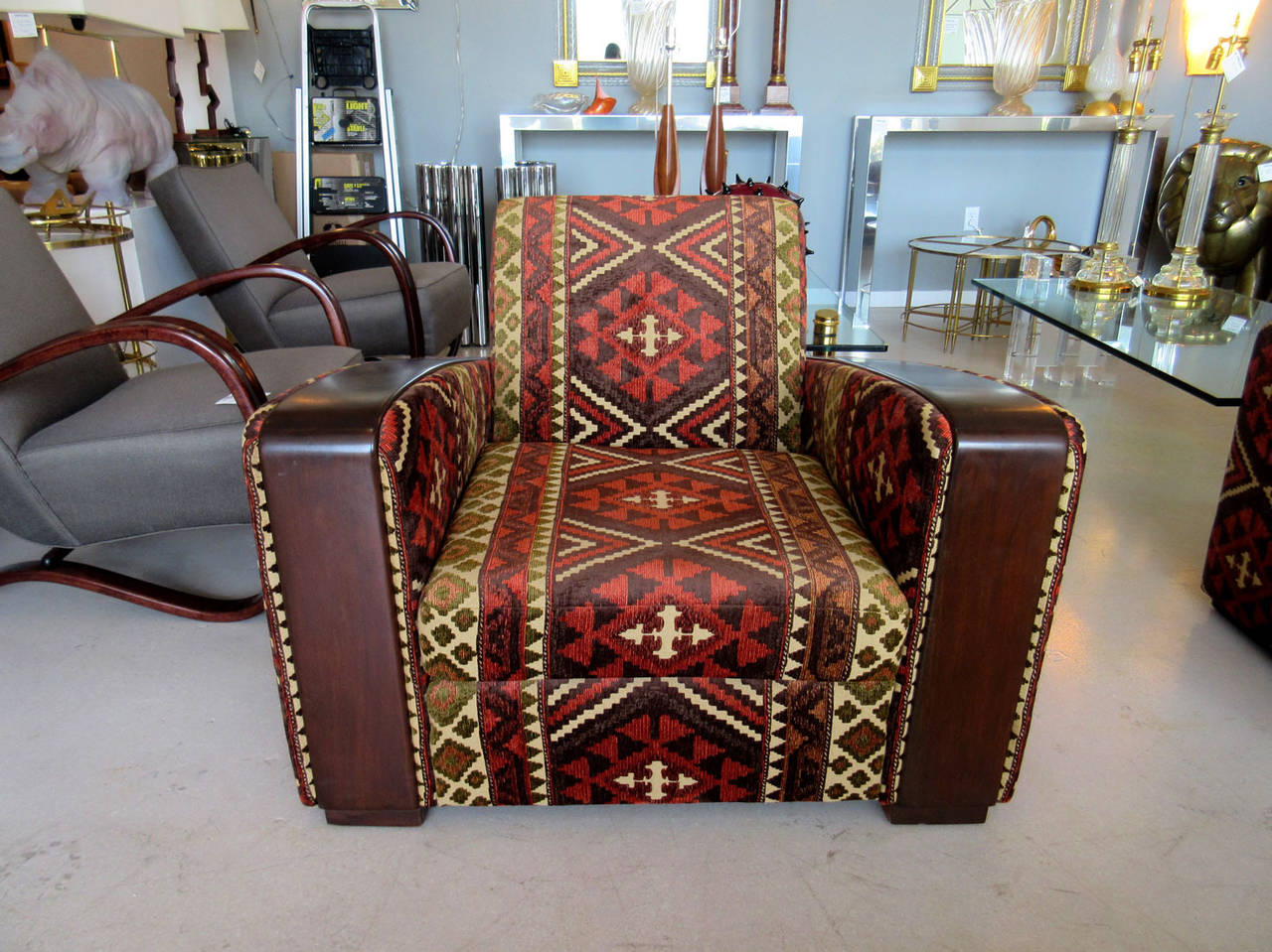 Pair of French art deco club chairs with arm rests and newly upholstered in a bold kilim fabric.
