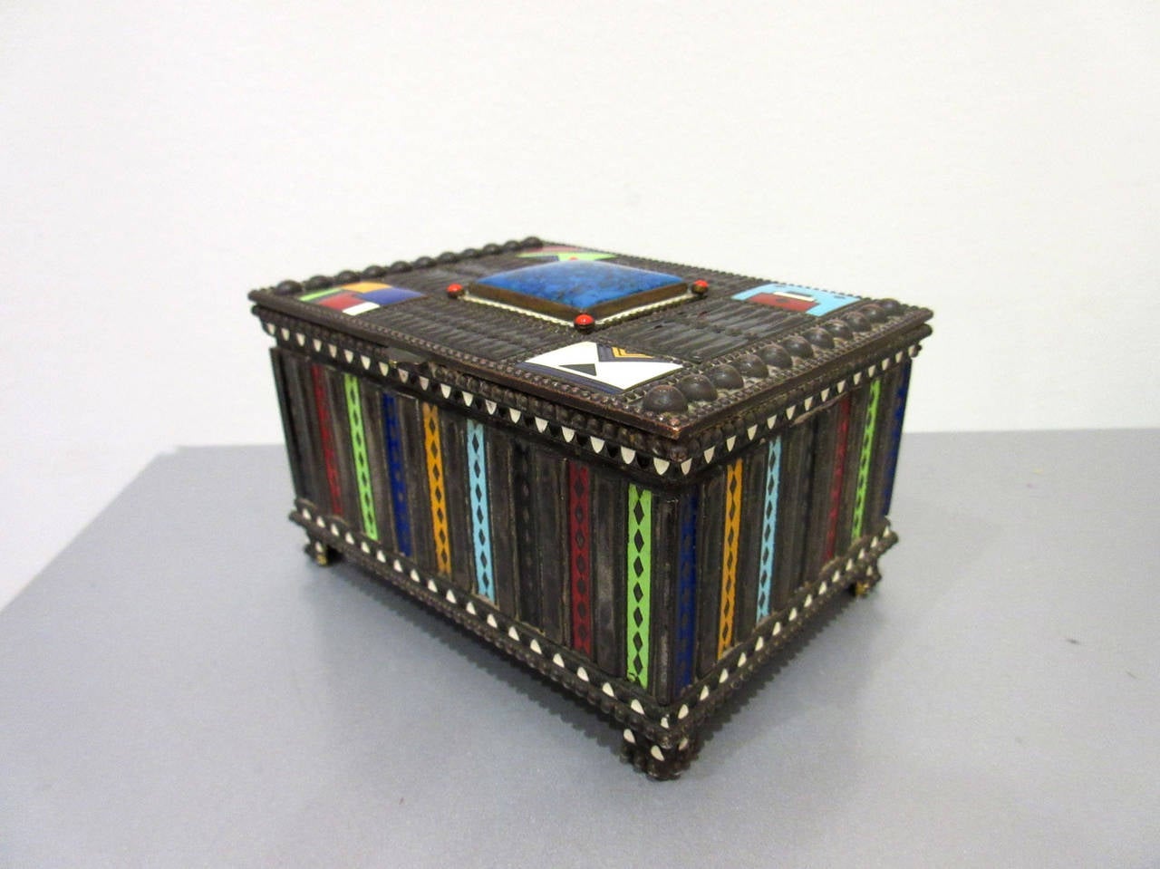 Antique Austrian silvered bronze jewelry box with intricate enamel embellishments. The enamel details are geometric and multicolored individual mini compositions adorning the lid. The interior is lined in original velvet. The box is marked on the