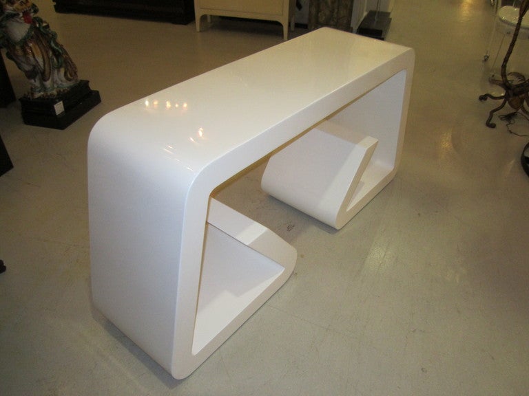 White lacquer geometric console table- simple in design- and attractive from all angles.