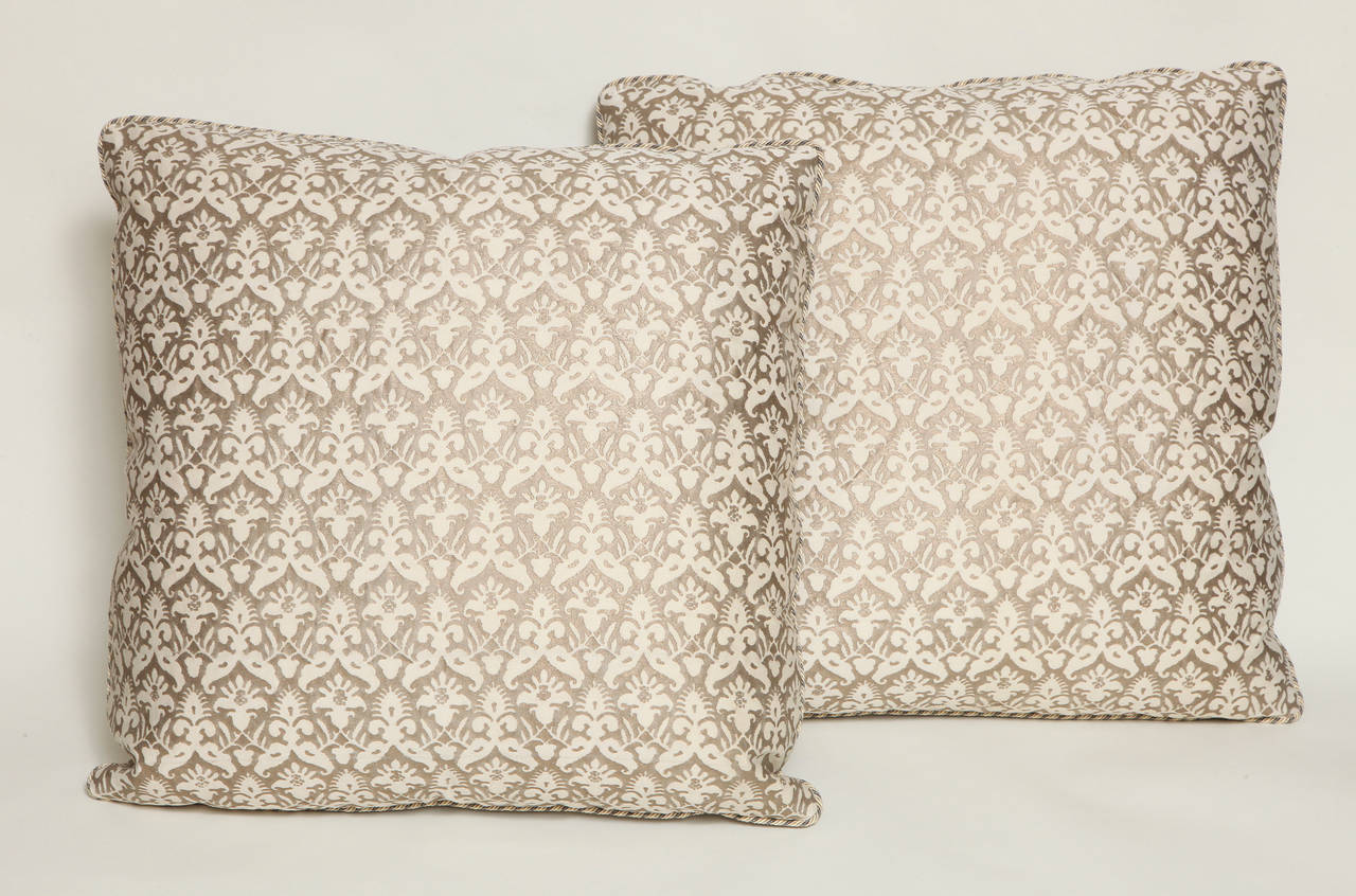 A pair of vintage Fortuny fabric silvery gold and ivory Delfino pattern cushions with silver tussah fabric backs and braided edging.