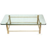 A Rectangular Coffee Table with Brass Base and Faux Bamboo Legs