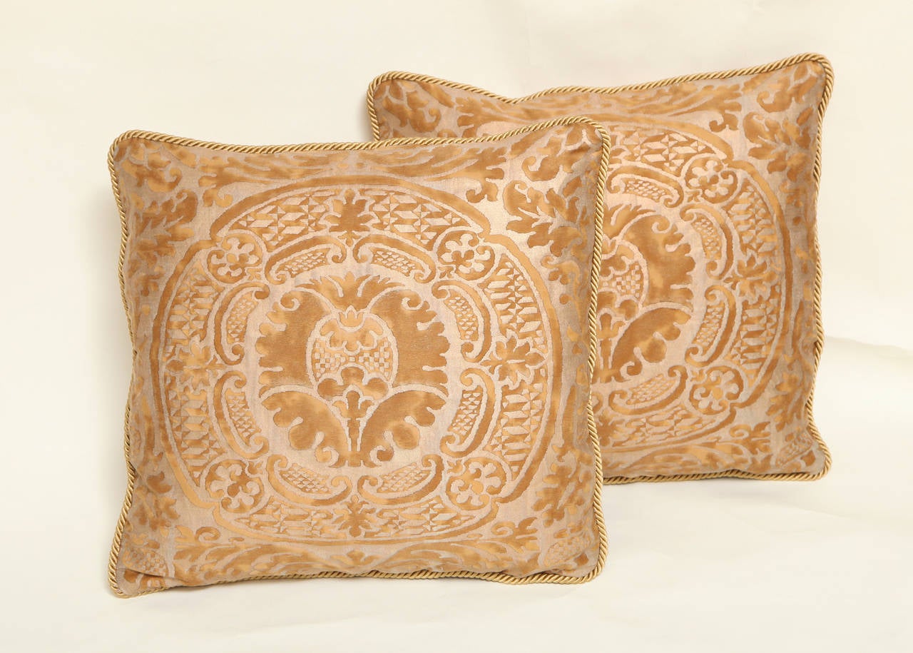 A pair of 1950s rectangular bronze Fortuny fabric cushions made with vintage Orsini pattern fabric having pineapple motif within medallion. The backs covered in sand colored linen, the edges with matching silk braid.
