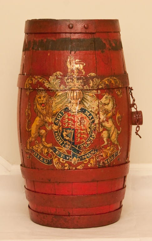 A barrel shaped English fire bucket with horizontal iron bands securing red painted oak vessel having transfer decoration with the British royal coat of arms.