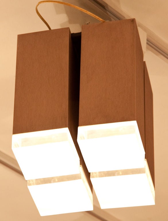 A Pair of Lightolier Ceiling Fixtures. Featuring a contemporary design of 4 light fixtures, the brushed metal frame in 4 square sections, with a textured lucite 1 inch-thick cap at the bottom, which is hinged to facilitate a change of light bulbs.